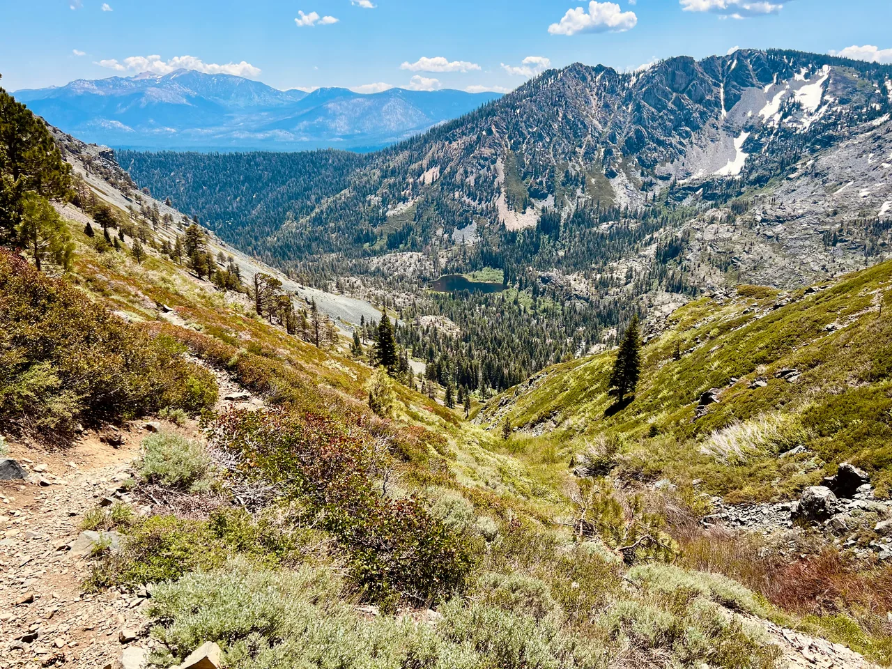 A dirt trail winding through a rocky mountain valley